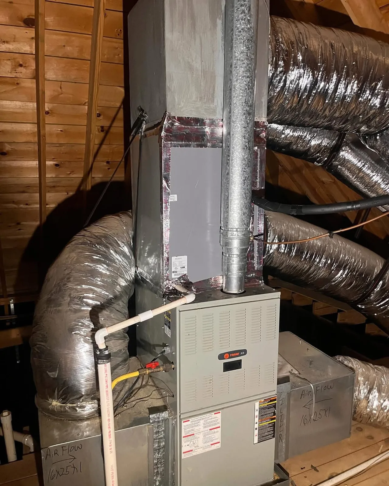 Gas furnace in a wooden attic closet with insulated flex ducts and a metal plenum