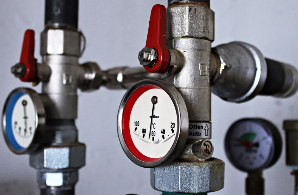 Pipes with red handled valves and pressure gauges